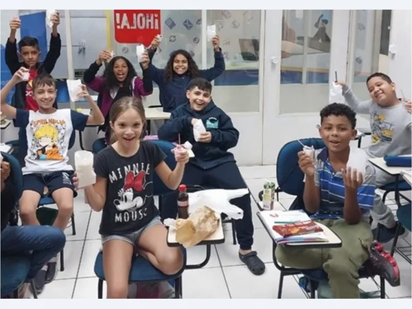 Turma reunida em sala de aula, com os alunos mostrando suas atividades.